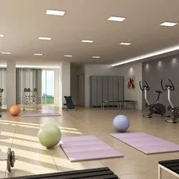 Ambiente interno amplo com piso claro e equipamentos de ginástica.