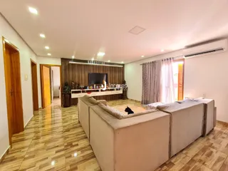Sala de estar com piso de madeira e sofá no interior de uma residência.