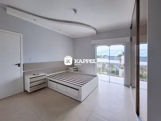 Quarto moderno com cama plataforma e armário branco em um apartamento.