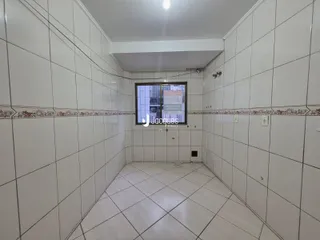 Corredor interno com piso de cerâmica e paredes brancas.