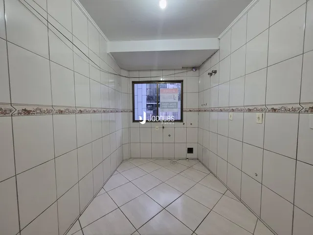 Corredor interno com piso de cerâmica e paredes brancas.