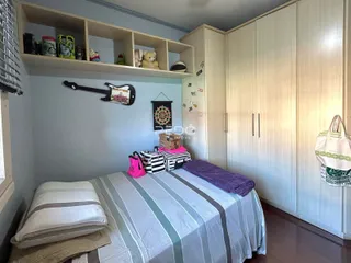 Quarto com armários embutidos e cama de casal em um apartamento.