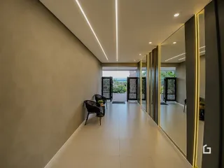 Corredor moderno com piso de cerâmica e iluminação embutida.