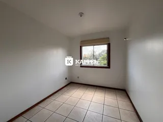 Vista interna de um cômodo com piso de cerâmica e janela.