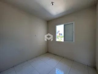Ambiente interno de uma sala vazia com piso de cerâmica e janela.