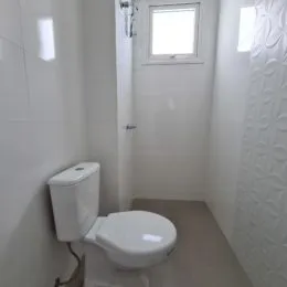 Foto de um banheiro com vaso sanitário branco.