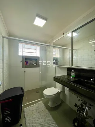 Foto de um banheiro com azulejos brancos e espelho.