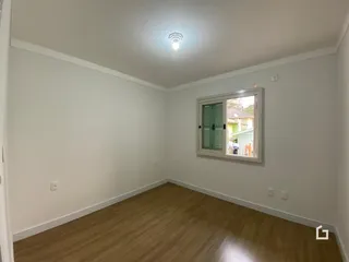 Foto de um cômodo interno com piso de madeira e paredes brancas.