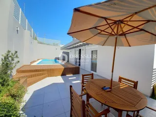 Vista externa de uma área de piscina e deck em uma residência.