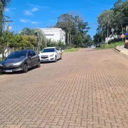 Vista da rua pavimentada em Lajeado, Brasil, com carros estacionados.
