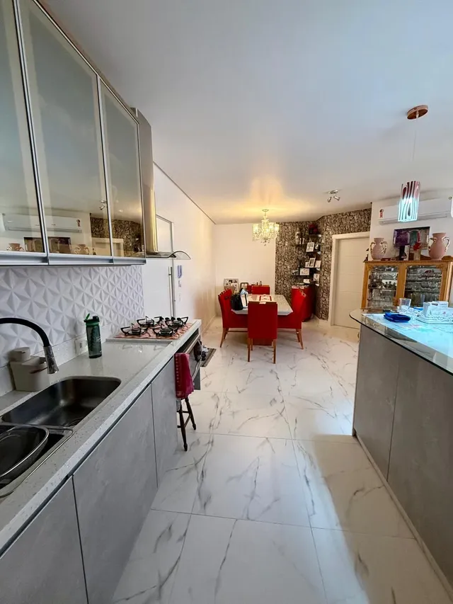 Uma cozinha e sala de estar com piso de mármore claro.