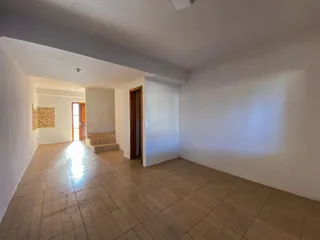 Hall de entrada com piso de cerâmica e paredes brancas.