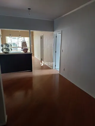 Vista interna de um ambiente com piso de madeira e paredes claras.