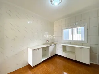 Ambiente interno com paredes brancas e piso de cerâmica marrom.