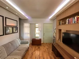 Sala de estar com sofá e piso de madeira.