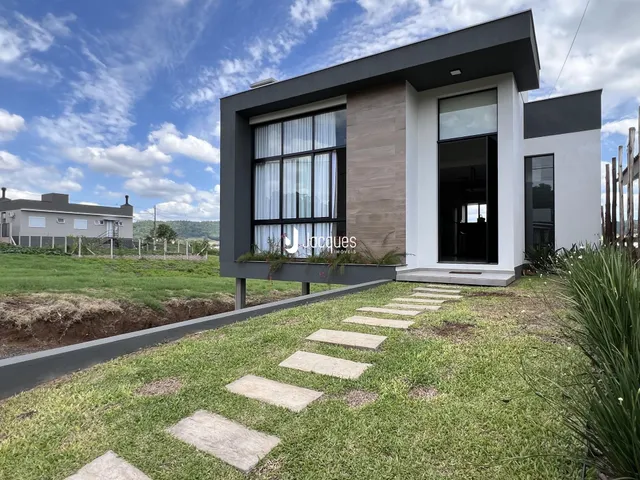 Fachada moderna de uma residência em Lajeado, Brasil, com jardim gramado.