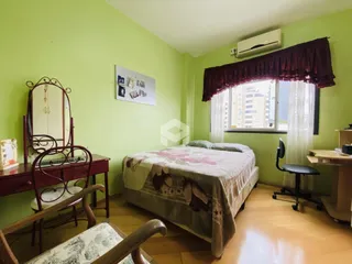 Quarto com paredes verdes e piso de madeira em Lajeado, Brasil.