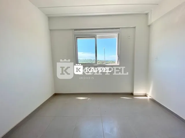 Foto de um cômodo interno com paredes brancas e uma grande janela.