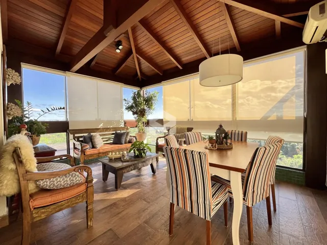 Sala de jantar com piso de madeira e teto de madeira no imóvel.