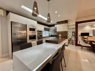 Cozinha moderna com ilha central e armários brancos.