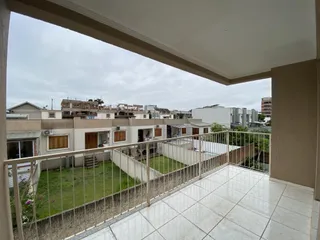 Vista da varanda com piso de cerâmica e grade metálica em um apartamento em Lajeado.