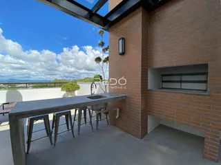 Vista de uma área externa com balcão e bancos em uma residência de tijolos.