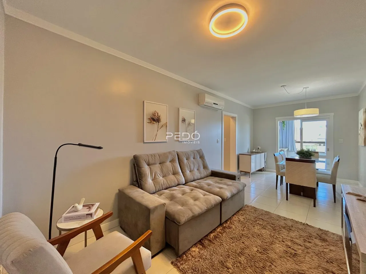 Sala de estar com sofá e decoração clara.