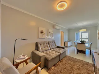 Sala de estar com sofá e decoração clara.