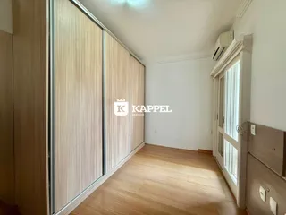 Quarto com armários em madeira e piso de madeira clara.
