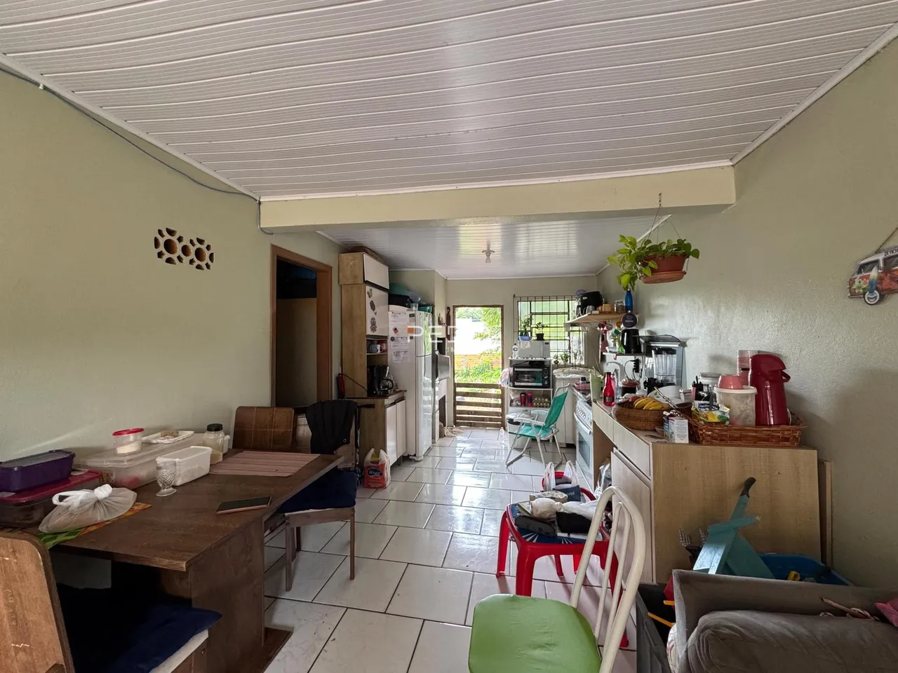 Ambiente interno de uma sala de estar com cozinha integrada em Lajeado, Brasil.