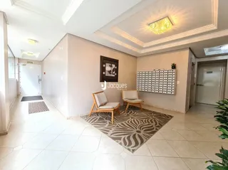 Sala de estar com piso de cerâmica e tapete no interior de uma residência.