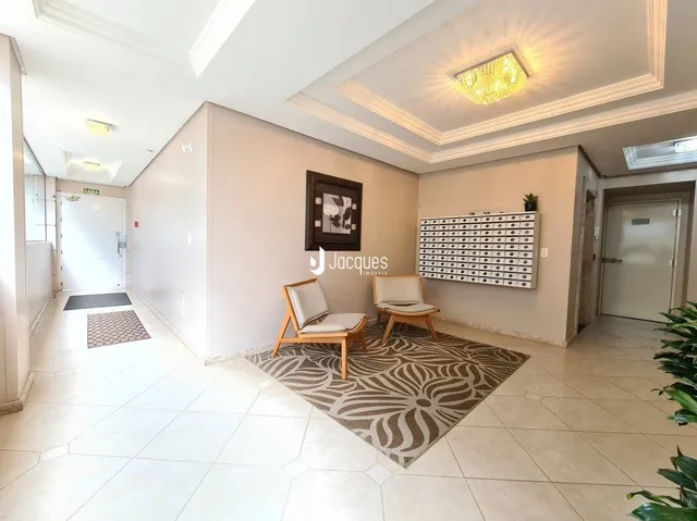 Sala de estar com piso de cerâmica e tapete no interior de uma residência.