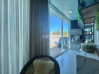 Vista de uma sala de estar com portas de vidro que dão acesso a uma área externa.