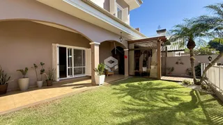 Fachada de uma residência com jardim gramado e área externa.