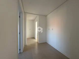 Hall de entrada com paredes brancas e piso claro.