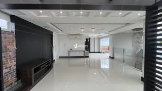 Interior de uma sala de estar moderna com piso de cerâmica e teto alto.