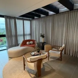 Uma sala de estar com cortinas claras e piso de madeira é visível na propriedade.