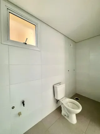 Foto de um banheiro interno com paredes brancas e um vaso sanitário.
