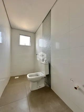 Foto de um banheiro moderno com revestimento branco e piso claro.