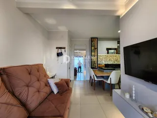 Sala de estar com sofá marrom e piso claro em um imóvel no Brasil.