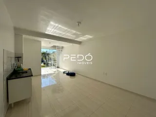 Interior de um espaço com piso de cerâmica e paredes brancas.