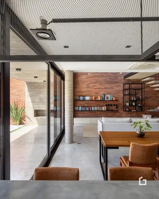 Sala de estar com paredes de tijolo aparente e piso de concreto.