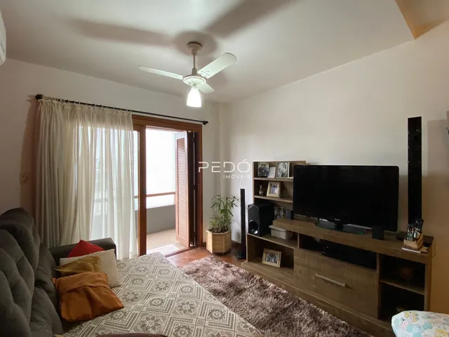 Quarto com sofá e televisão em ambiente claro.