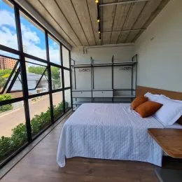 Foto de um quarto com cama e grandes janelas em um imóvel.