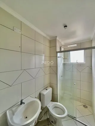 Foto de um banheiro com azulejos brancos e box de vidro.