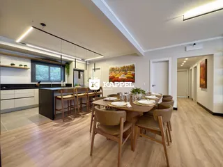 Uma sala de jantar moderna com mesa de madeira e iluminação clara.