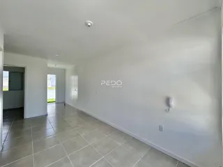 Hall de entrada com piso de cerâmica claro.