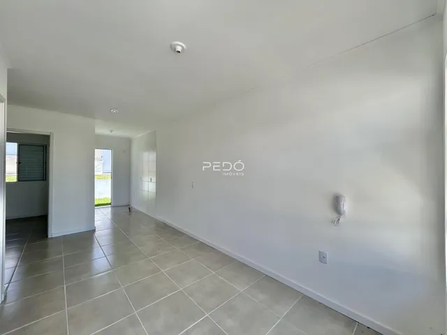 Hall de entrada com piso de cerâmica claro.