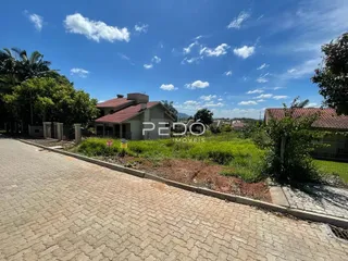 Fachada de uma residência em Lajeado, Brasil, com jardim e calçada de tijolos.