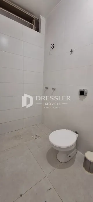 Foto de um banheiro com piso de cerâmica e paredes brancas.